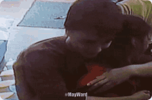 a man and woman are hugging on a couch .