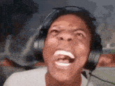 a man wearing headphones is making a funny face while playing a video game .