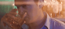 a man is drinking a glass of whiskey with ice