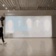 a person is standing in front of a large screen