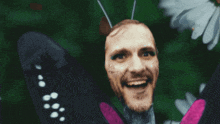 a butterfly with a man 's head on it 's wings