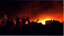 a man with red hair and blue eyes stands in front of a burning building