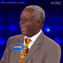 a man wearing a suit and tie has a name tag that says george