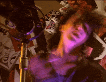 a blurry picture of a person singing into a microphone with purple lights