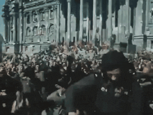 a large crowd of people are gathered in front of a building