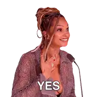 a woman with dreadlocks is smiling and saying yes in front of a microphone