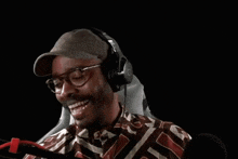 a man wearing headphones and a hat is sitting in a chair