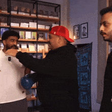a man wearing a red hat with the letter r on it is talking to another man