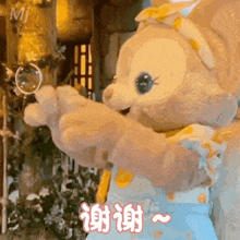 a stuffed animal with chinese writing on it is giving a thumbs up