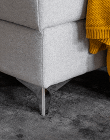 a white couch with a yellow blanket on it