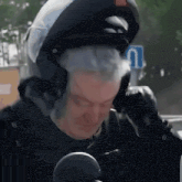 a man wearing a helmet is talking on a cellphone
