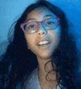 a young girl wearing glasses and a purple shirt