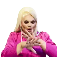 a woman in a pink dress is making a hand gesture with her hands