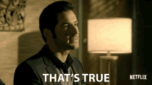 a man in a suit says " that 's true " next to a lamp