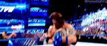 a blurry picture of a wrestling match with the next big thing written on the bottom right