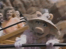 miss piggy is wearing a hat and holding a pole
