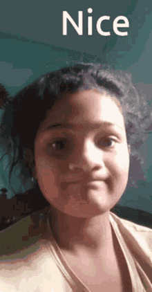 a young girl is making a funny face with the words nice behind her