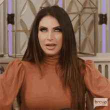 a woman is wearing a sweater with the word bravo on the bottom