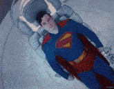 a man in a superman suit is laying in an oxygen chamber