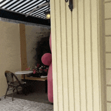 a pink balloon is hanging on a wall next to a table and chairs