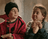 a boy wearing a red jacket with the number 5 on the front