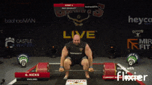 a man squatting down with a barbell in front of a sign that says castle water