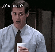 a man in a suit and tie is holding a cup of coffee and making a funny face with the word yaaaa written above him