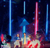 a group of people are dancing on a stage with a man wearing a varsity jacket that says bc