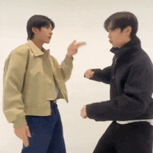a couple of men are standing next to each other and one is pointing at the other