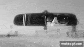 a woman wearing sunglasses is looking at herself in the rear view mirror .