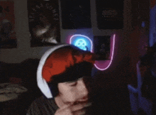 a man wearing headphones with a neon light on his ear