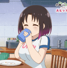 a girl drinking from a blue mug with the letter u on the front