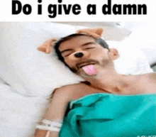 a man is laying in a hospital bed with his tongue out and a dog face mask on his face .