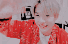 a man wearing a red bandana and a white shirt smiles