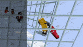 a screenshot of a video game with a yellow character holding a gun behind a glass fence .