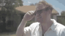 a man is wearing sunglasses and talking on a cell phone .