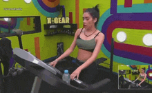a woman is running on a treadmill in a gym with a sign that says x-gear