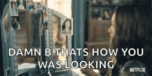 a woman is sitting in front of a mirror looking at herself in the mirror .