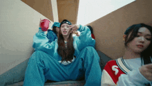 a girl wearing a sweatshirt with the letter s on it sits on a set of stairs