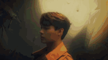 a young man wearing a yellow jacket is standing in a dark room .
