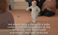 a baby is in a dance as a baby contest and looks at the other one with a confused expression and their arms out