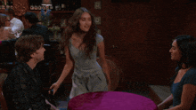 a woman in a blue dress is dancing in front of a man in a plaid shirt