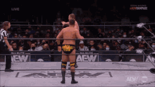 a wrestler with the word ego on his shorts is standing in the ring