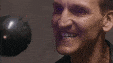 a close up of a man 's face with a purple light shining on it