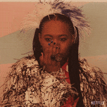 a woman wearing feathers and a ring with netflix written on the bottom right