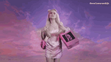 a woman in a pink dress is holding a pink bag