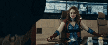 a woman in a superhero costume sits in a chair with her arms outstretched