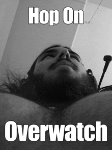 a man with a beard is laying down with the words hop on overwatch below him