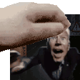 a hand is reaching out towards a man in a suit and tie in a blurry photo .