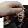 a hand is reaching out towards a man in a suit and tie in a blurry photo .